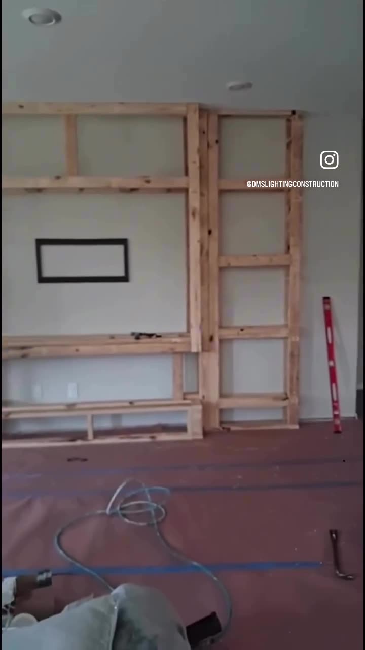 Stud framing for a custom media wall with shelving bays roughed in